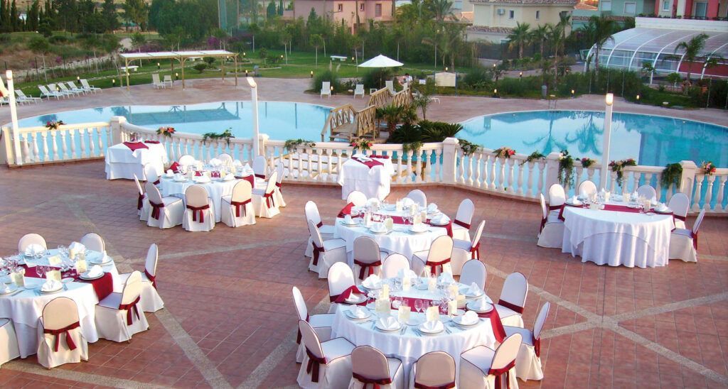 Terraza del Hotel Bonalba con mesas redondas montadas junto a la piscina