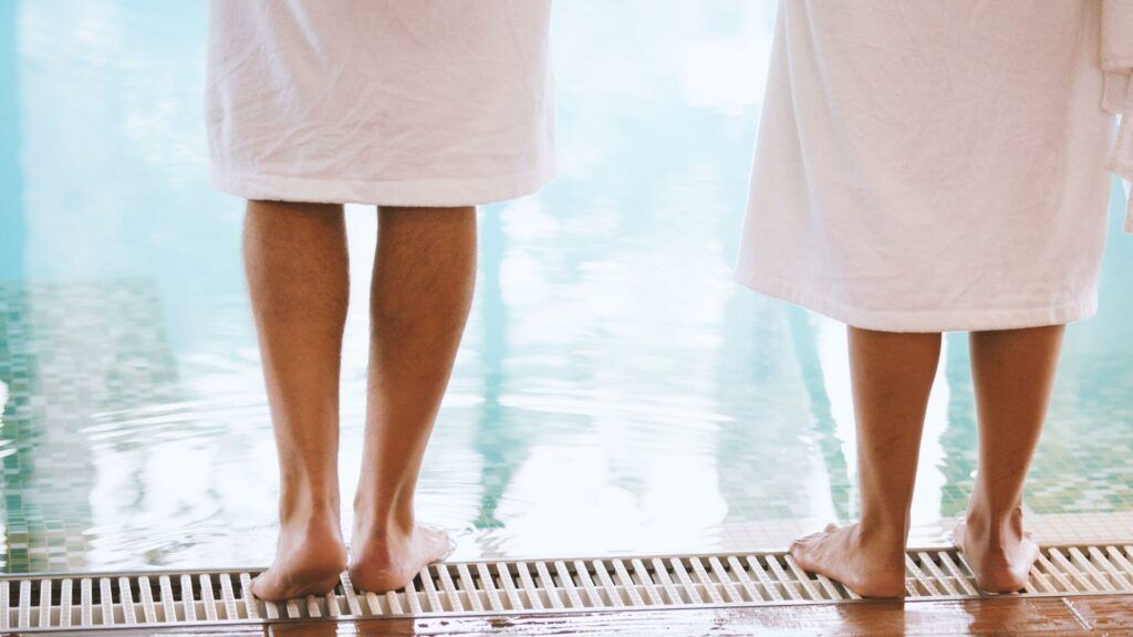 Pareja en albornoz junto a la piscina climatizada del Wellness & Beauty Center del Hotel Bonalba