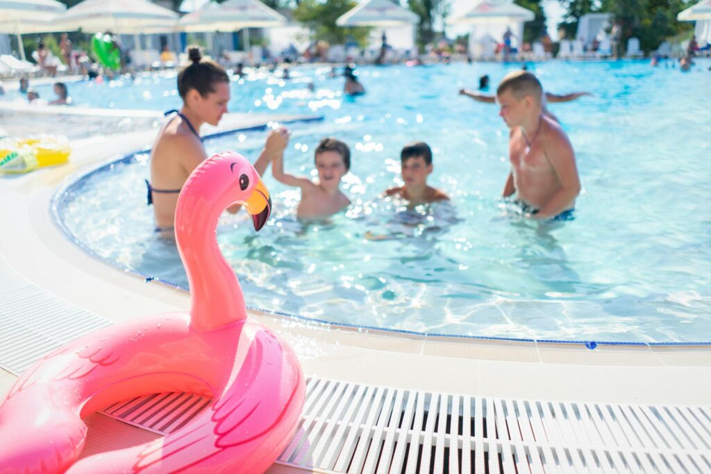Family playing in a hotel swimming pool on a summer holiday in Alicante