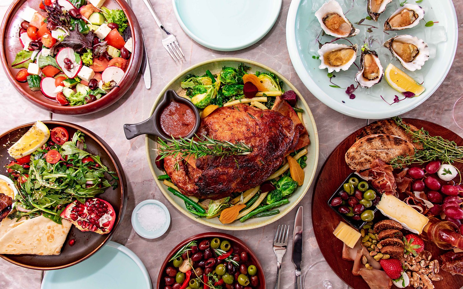 Mesa festiva del D&iacute;a de Navidad con asado, ensaladas, entrantes y tabla de embutidos y quesos