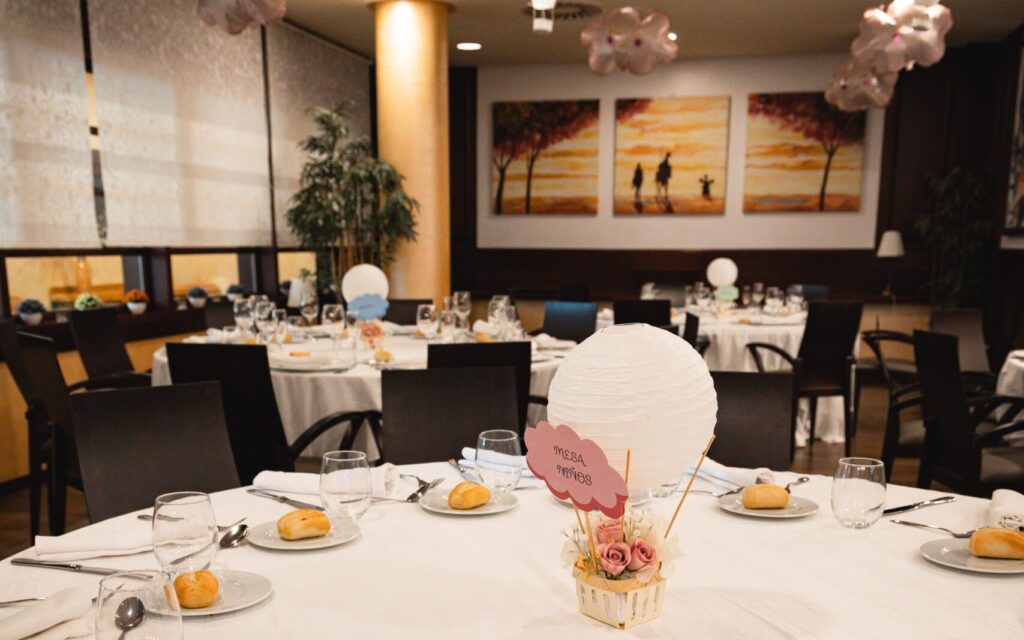 Mesa de comunión con centro de flores y globos en el Hotel Bonalba